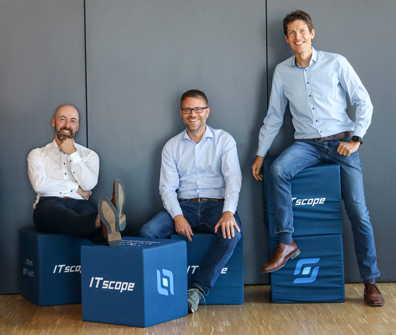 Das ITscope Management bestehend aus Andy Görnt, Benjamin Mund und Stefan Reger sitzt locker auf Sitzwürfeln im Büro